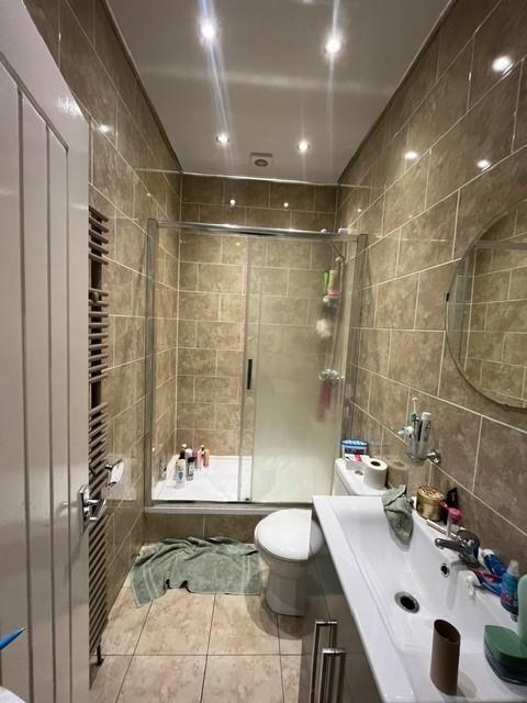 Contemporary tiled bathroom with a glass shower...