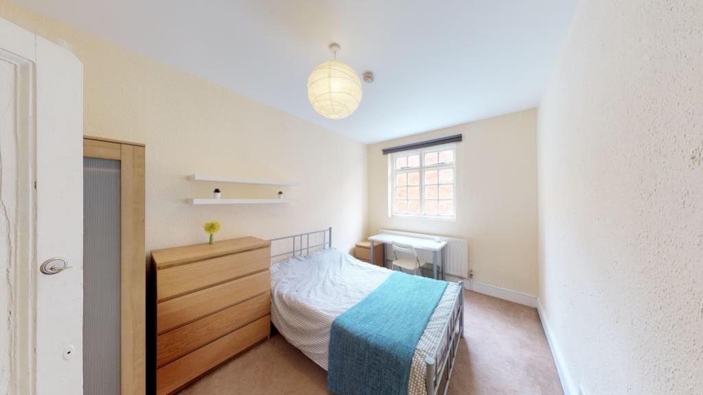 A bright and tidy single bedroom featuring a co...