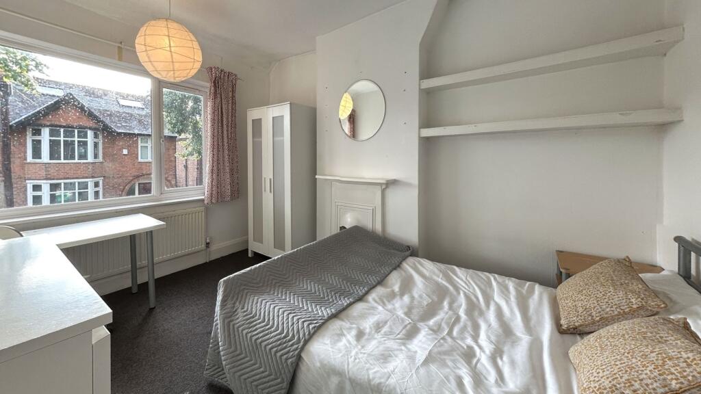 A bright and inviting bedroom with a large wind...