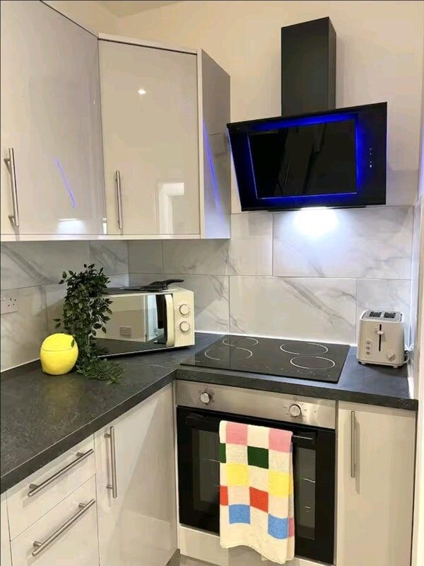 Modern kitchen corner featuring sleek white cab...