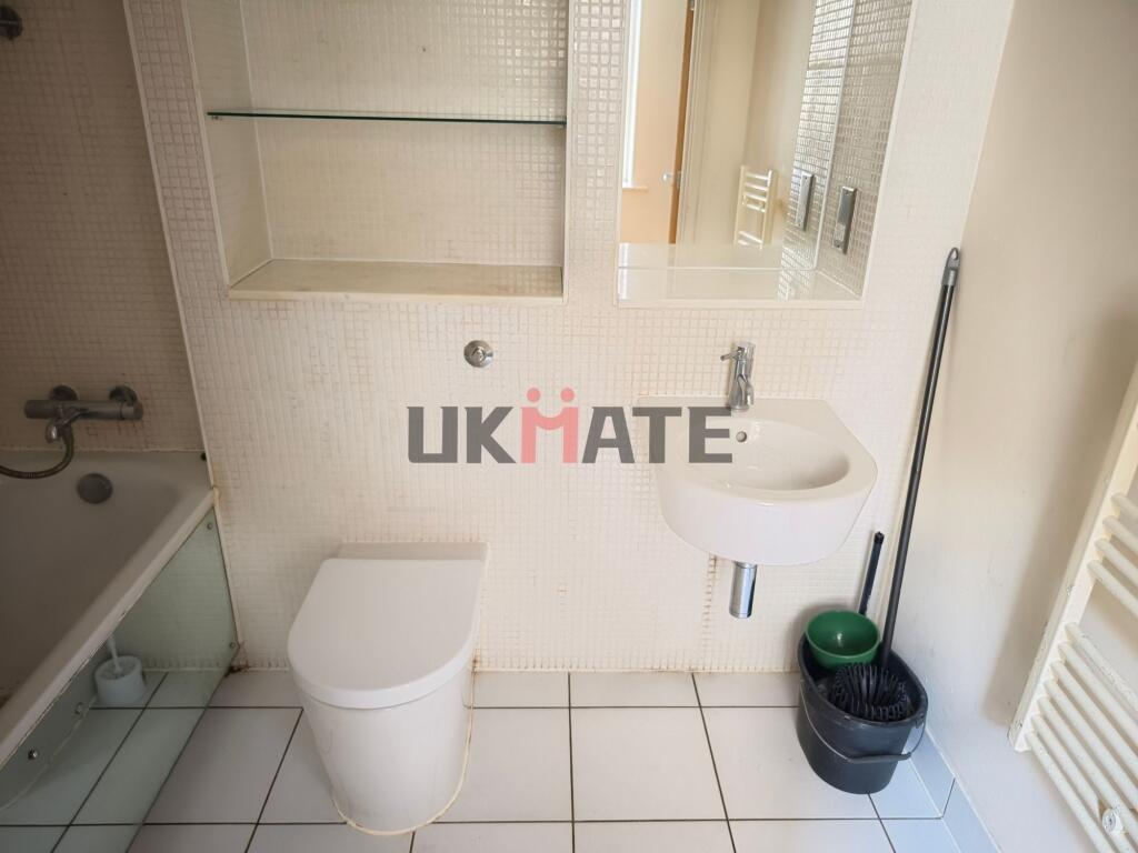 Functional bathroom featuring a toilet, a small...