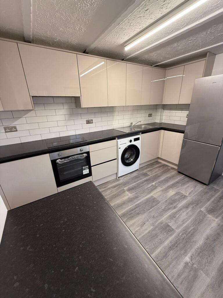 This modern kitchen features sleek, high-gloss ...