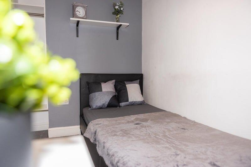 A well-kept single bedroom featuring a comforta...