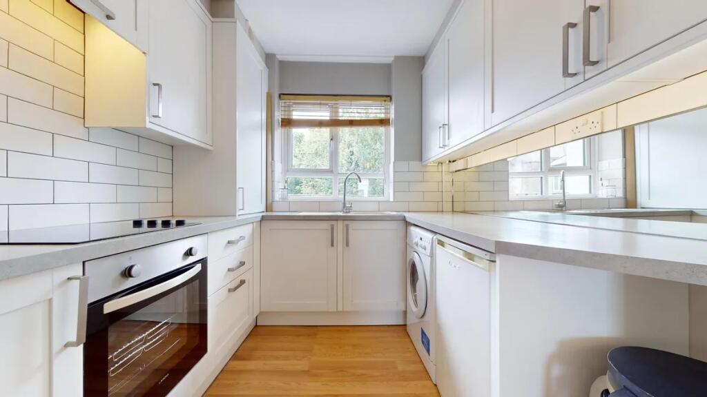 Bright and modern kitchen featuring white cabin...