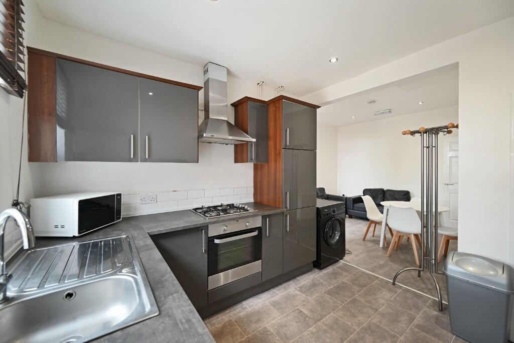 Contemporary kitchen with sleek dark cabinetry,...