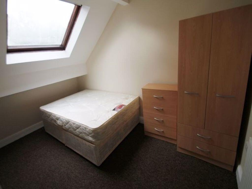 Bright attic bedroom with a sloped skylight pro...