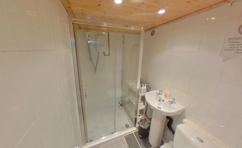 A modern bathroom featuring a glass-enclosed sh...
