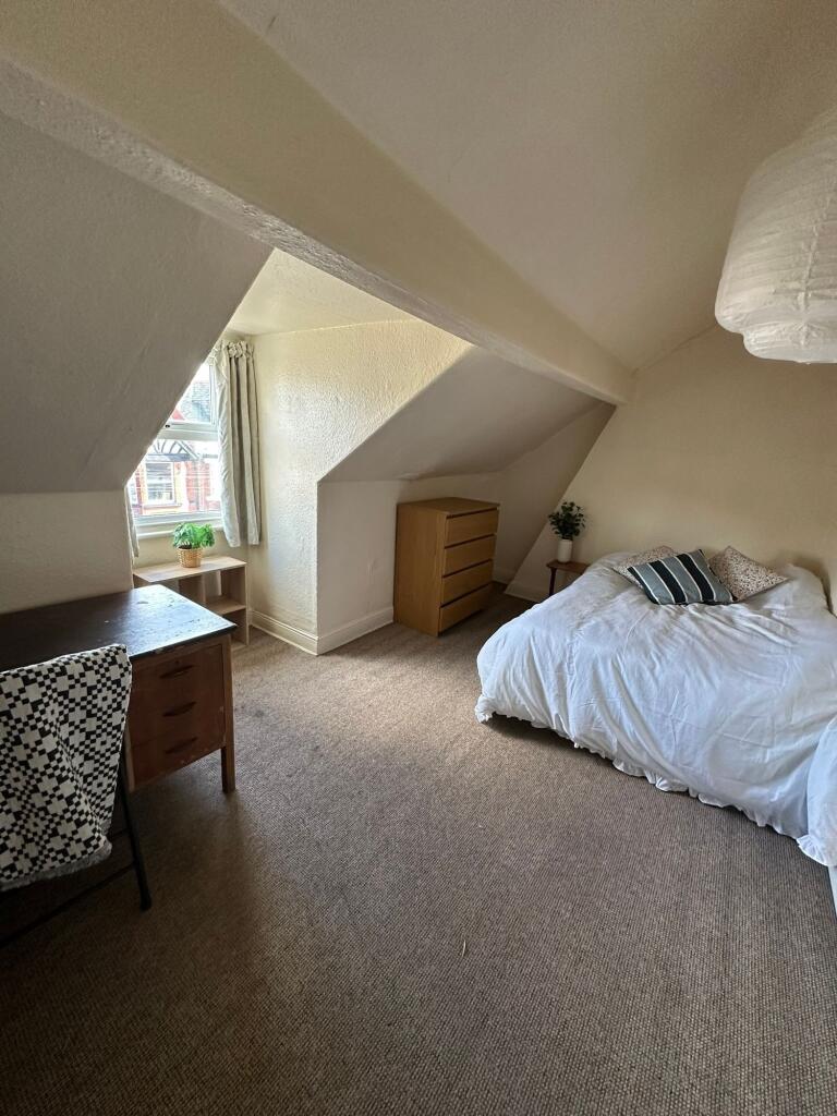 Bright and cozy master bedroom featuring a comf...