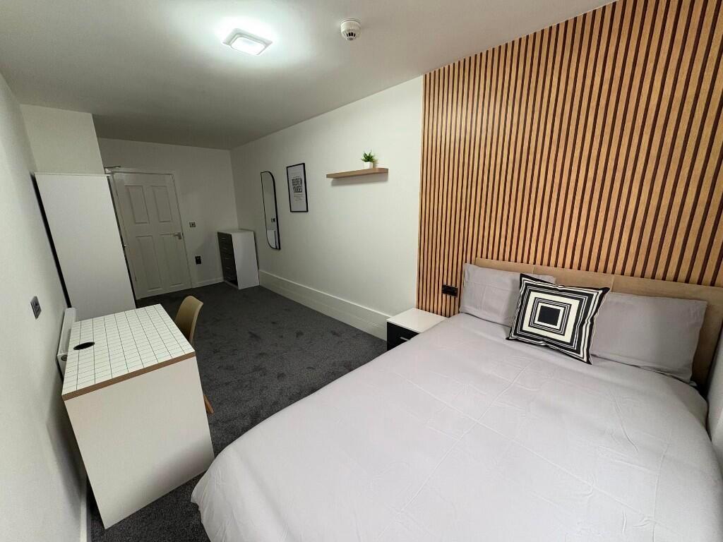 A stylish and spacious bedroom featuring a comf...