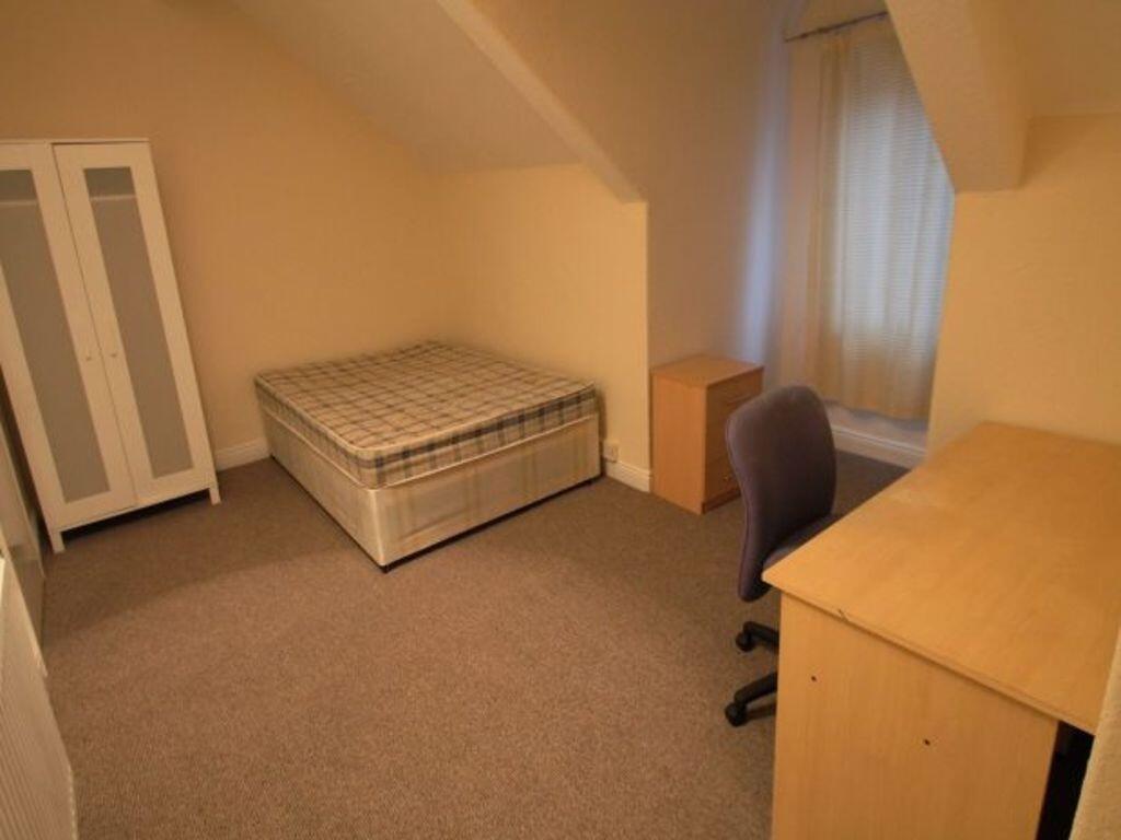 A clean and tidy single bedroom featuring a com...