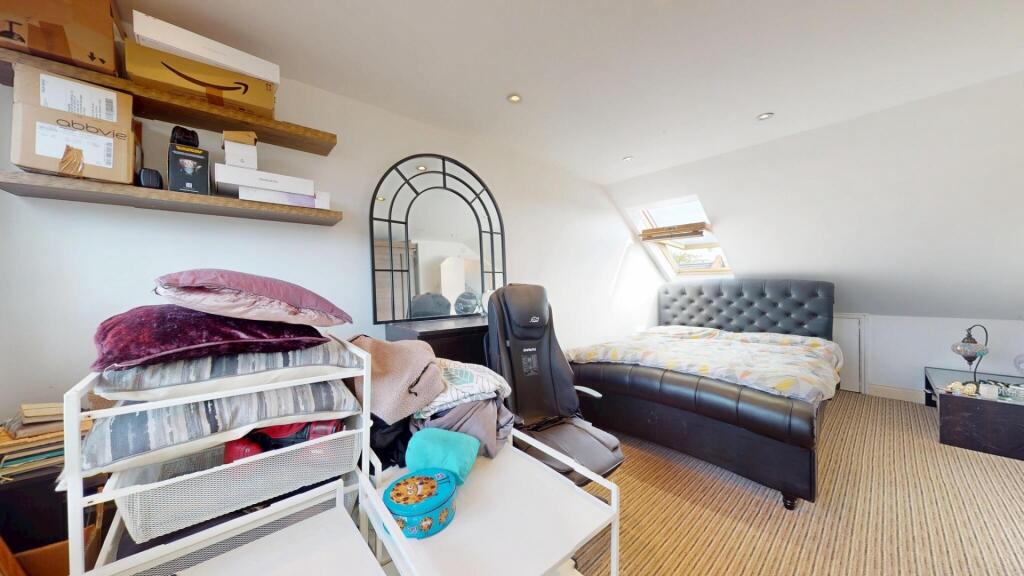 A cozy attic bedroom featuring a comfortable si...