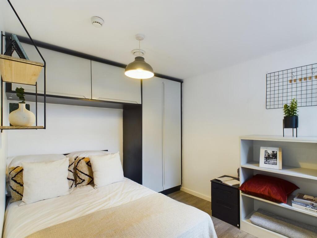 A modern and stylish double bedroom featuring a...