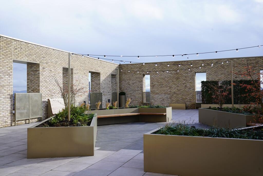 A modern rooftop garden featuring large raised ...
