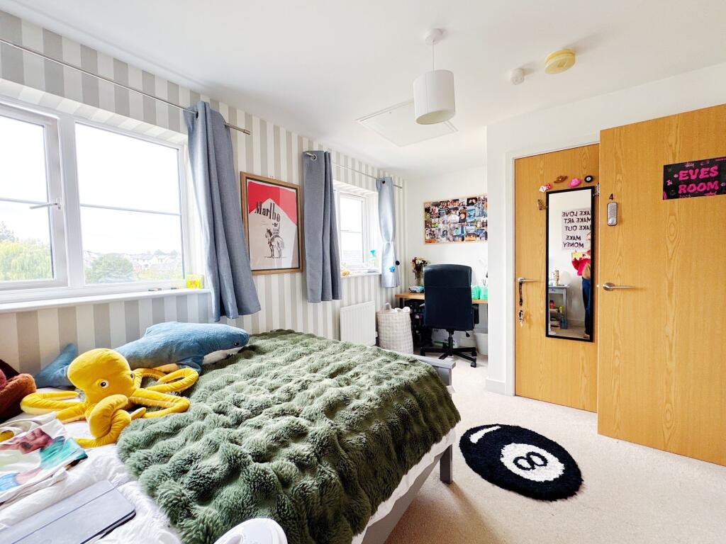 Bright and cozy bedroom featuring a large bed w...