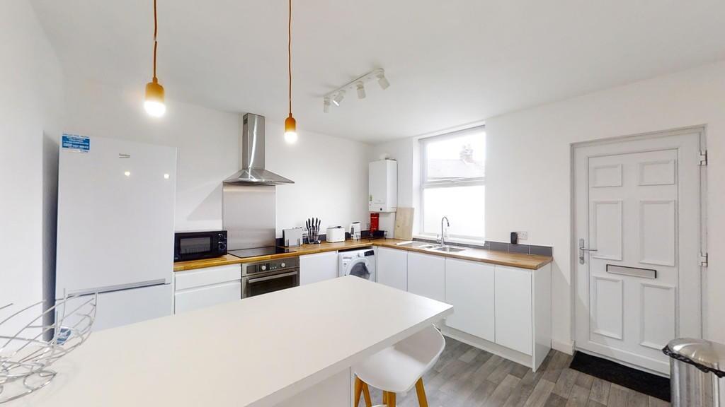 Bright and modern kitchen featuring white cabin...