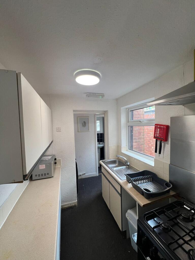 Compact kitchen space featuring a gas hob, stai...