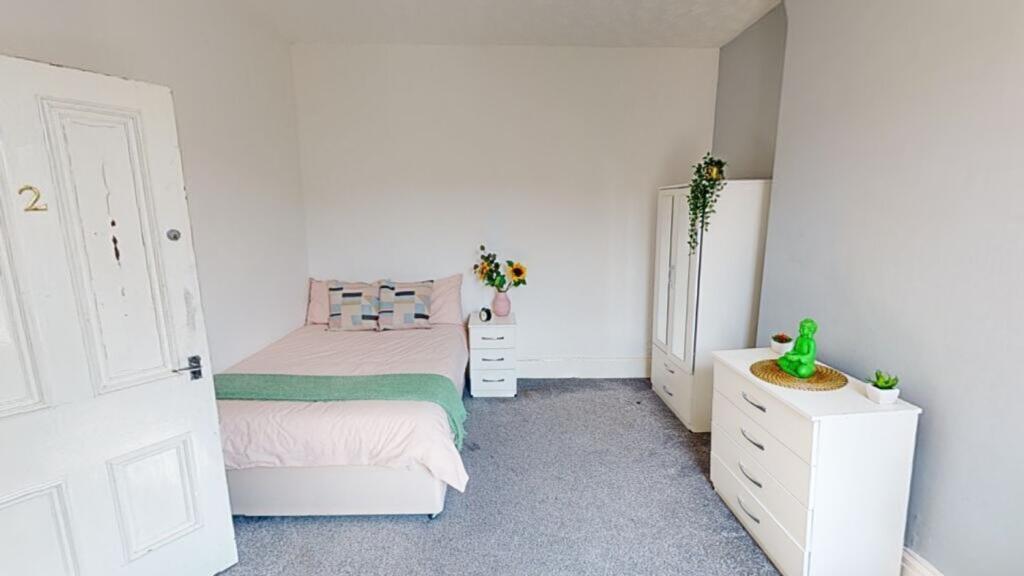 A bright and inviting double bedroom with moder...
