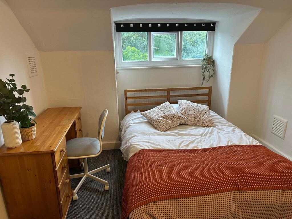 A cozy bedroom featuring a comfortable double b...