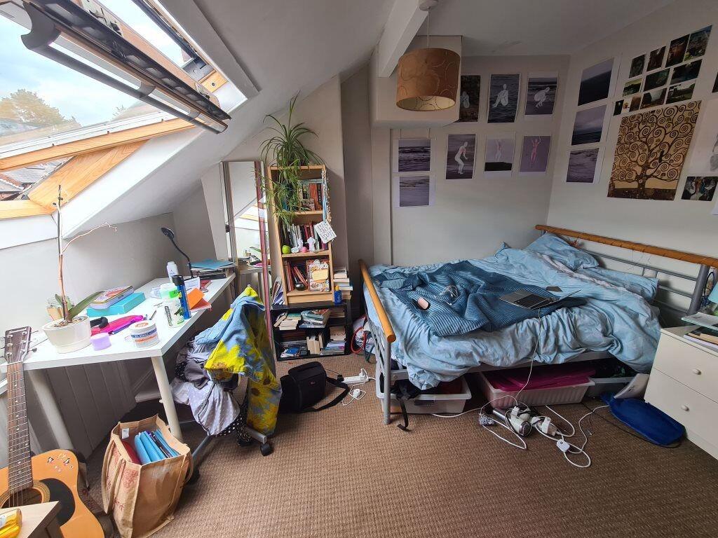 A cozy bedroom with a bed, some furniture, and ...