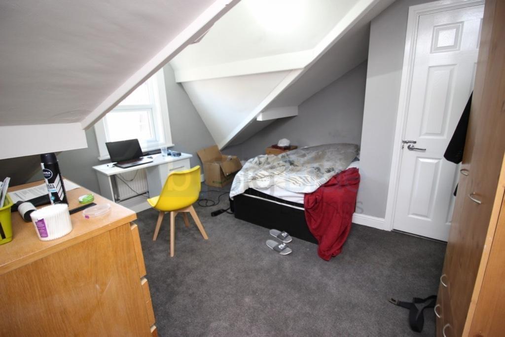 A cozy single bedroom featuring a comfortable b...