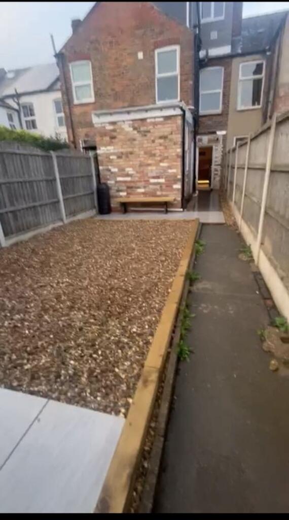 This charming garden space features a well-main...
