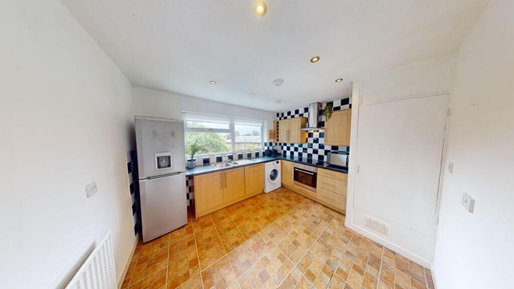 A bright and modern kitchen featuring ample cou...