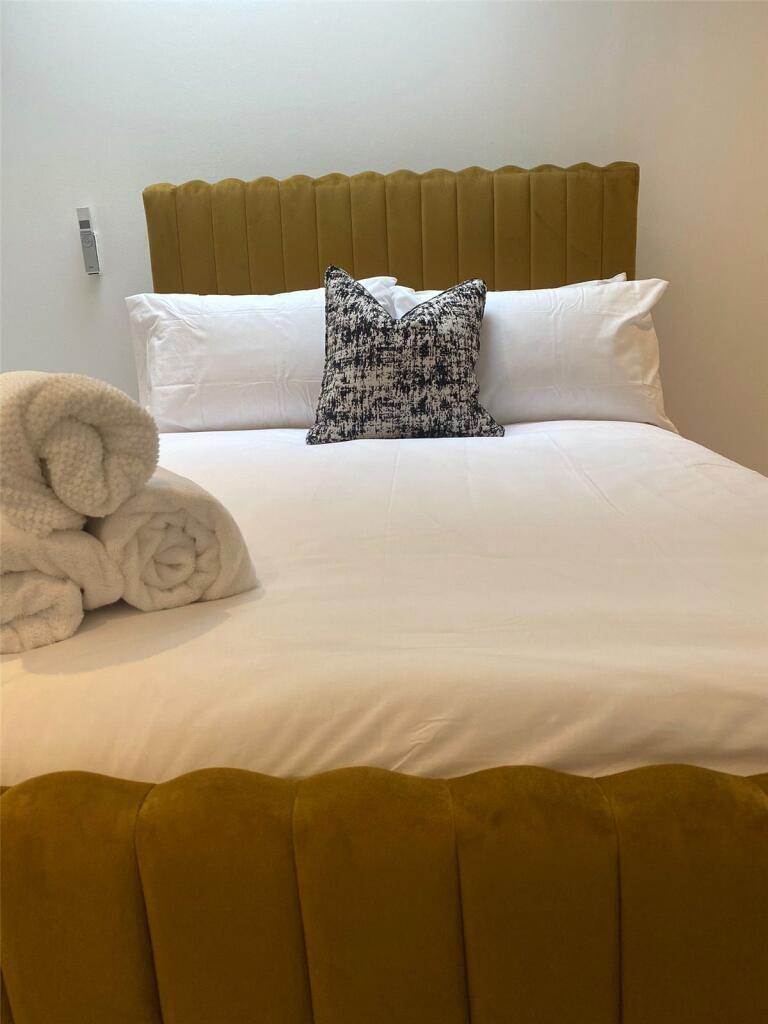 A spacious master bedroom featuring a comfortab...
