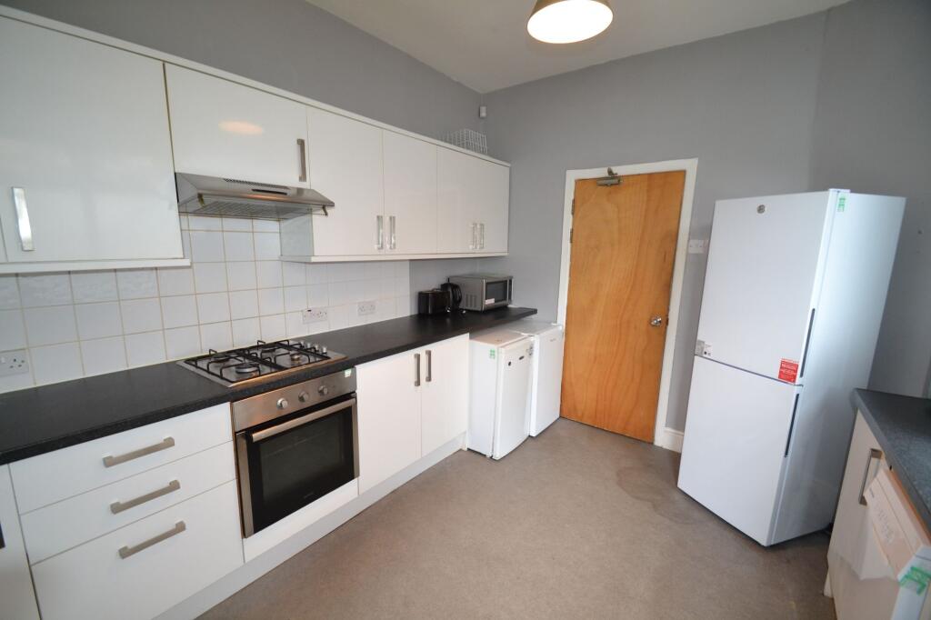 A modern kitchen featuring sleek white cabinetr...