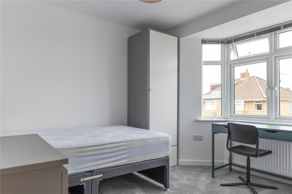 A bright and tidy room featuring a large window...