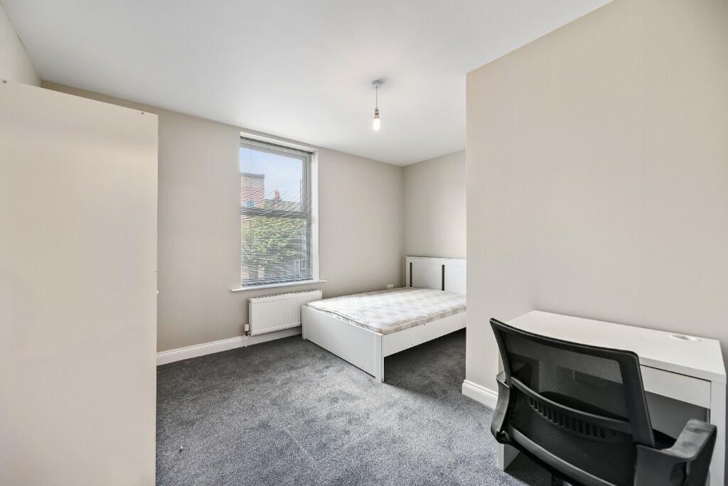 A bright and clean double bedroom featuring a c...