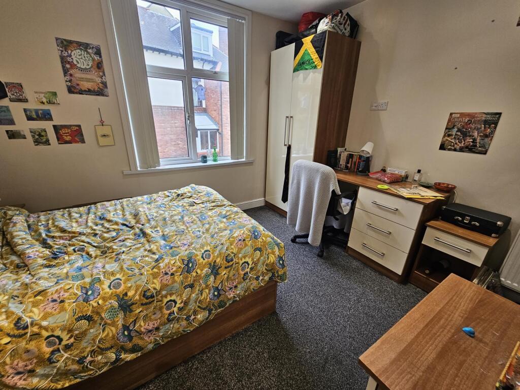 A cozy and well-maintained bedroom featuring a ...