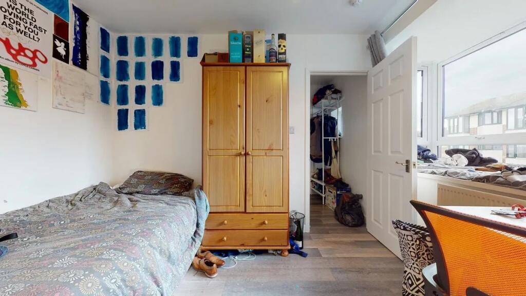 A cozy single bedroom featuring a comfortable b...