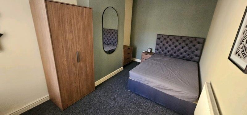 A cozy double bedroom featuring a stylish tufte...