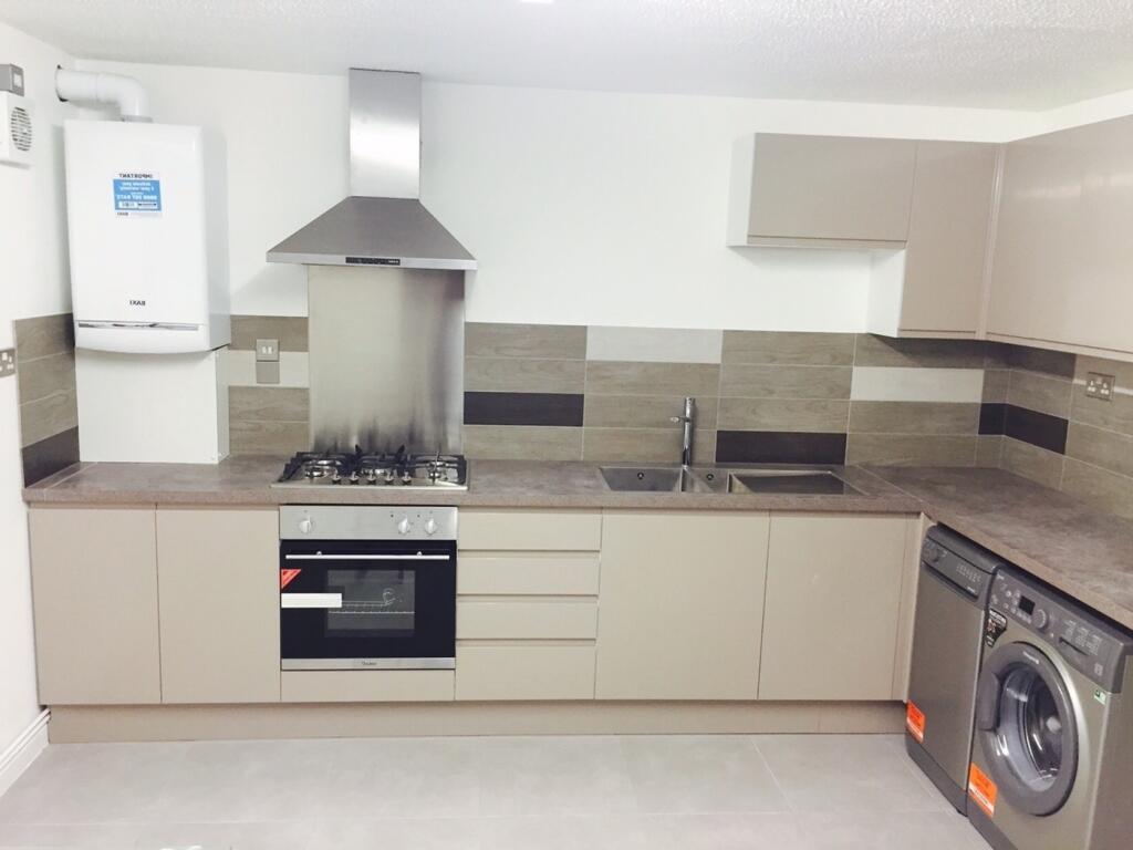 A modern and clean kitchenette with ample stora...