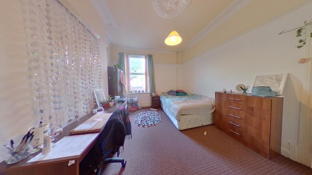 A spacious and well-lit bedroom featuring a lar...