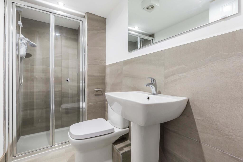 A clean, modern bathroom featuring a spacious s...