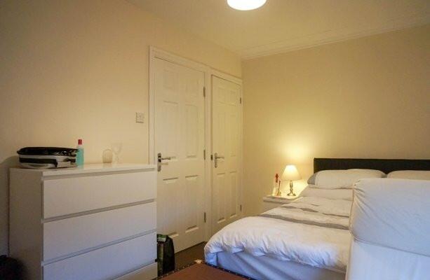 A bright and tidy bedroom featuring a large bed...