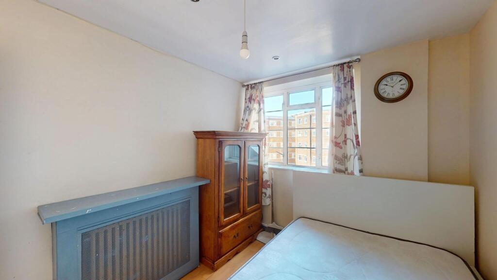 A cozy bedroom featuring a single bed, an antiq...