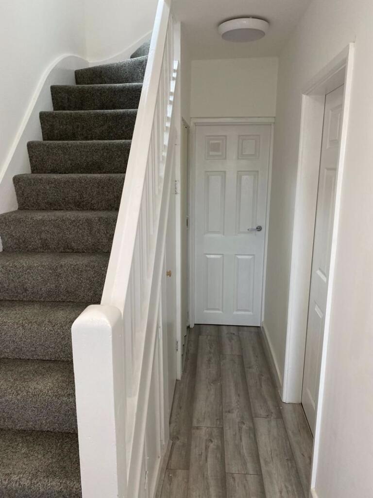 A clean and modern hallway featuring light wood...