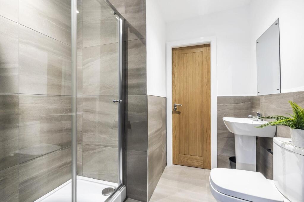 Bright modern bathroom with a walk-in glass sho...