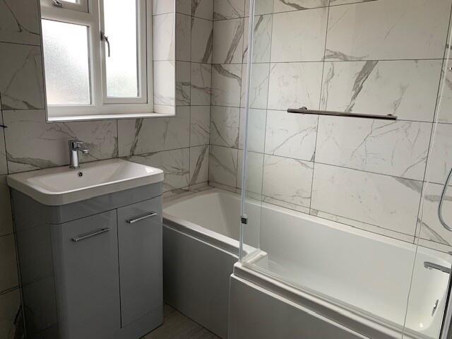 Bright and modern bathroom suite featuring a sl...