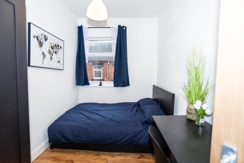 This cozy double bedroom features a comfortable...