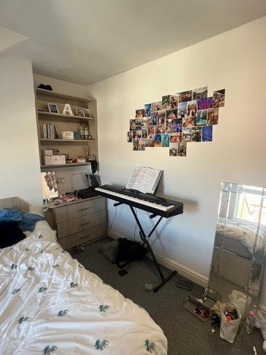 A cozy bedroom featuring a bed with a patterned...