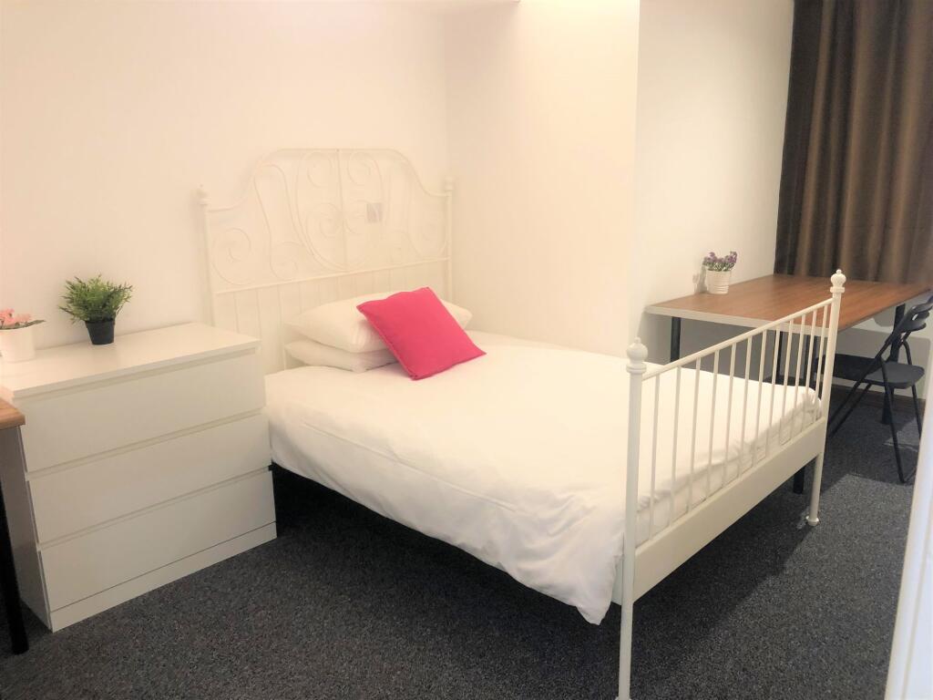 A neat and bright single bedroom featuring a wh...