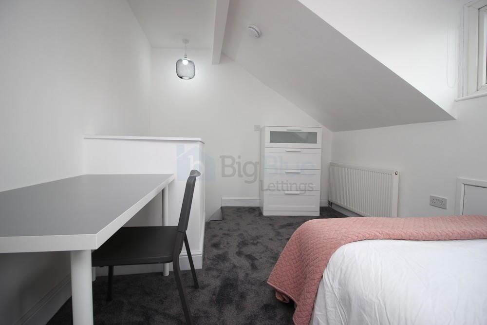 A neat and modern single bedroom featuring a co...