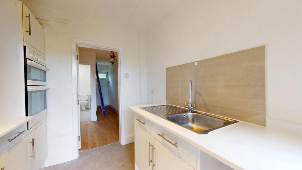 Bright and clean kitchen area with modern fixtu...
