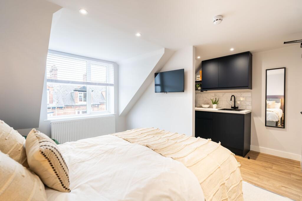 Bright and modern bedroom featuring a large bed...