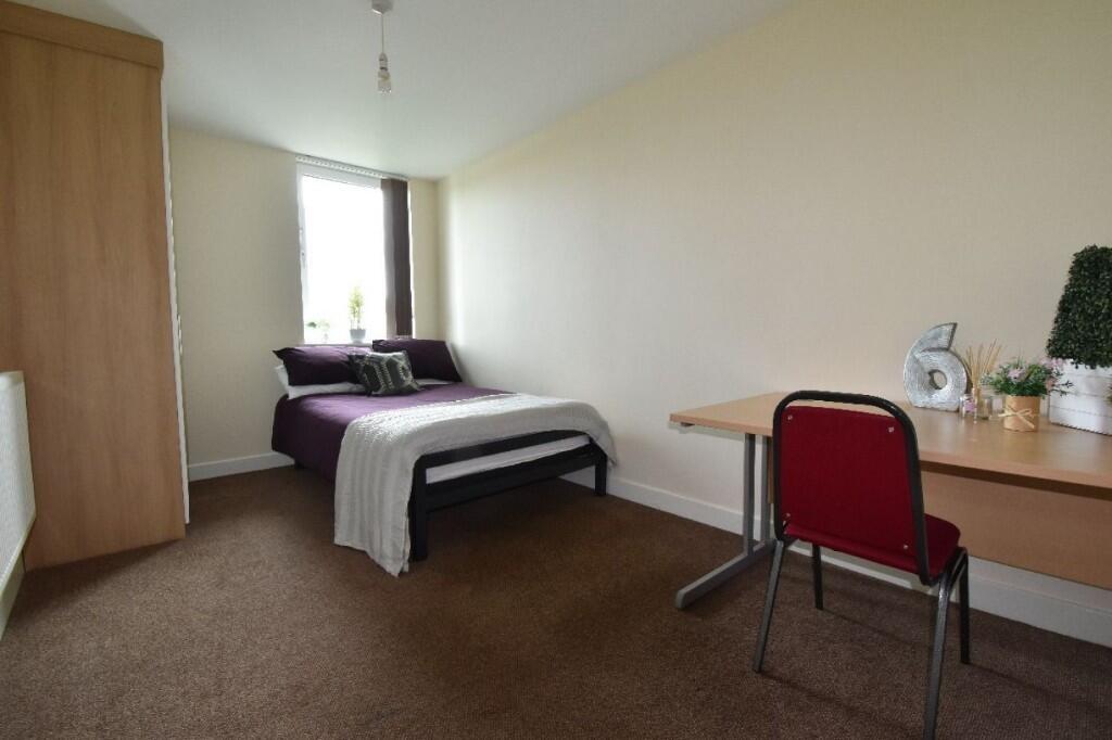 A neat and comfortable single bedroom featuring...