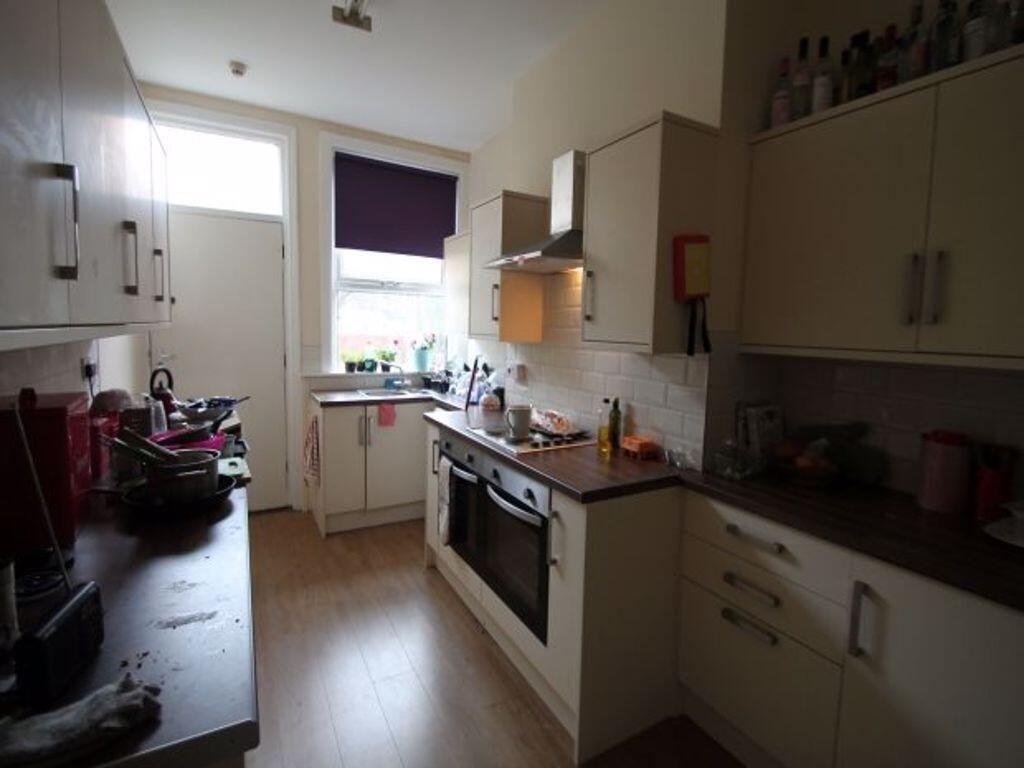 A modern kitchen featuring light cabinetry and ...