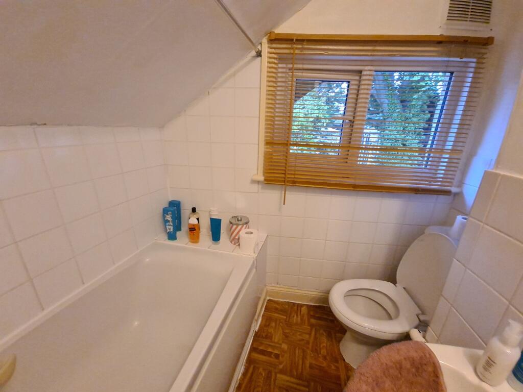 Tidy bathroom with a bathtub, toilet and small ...